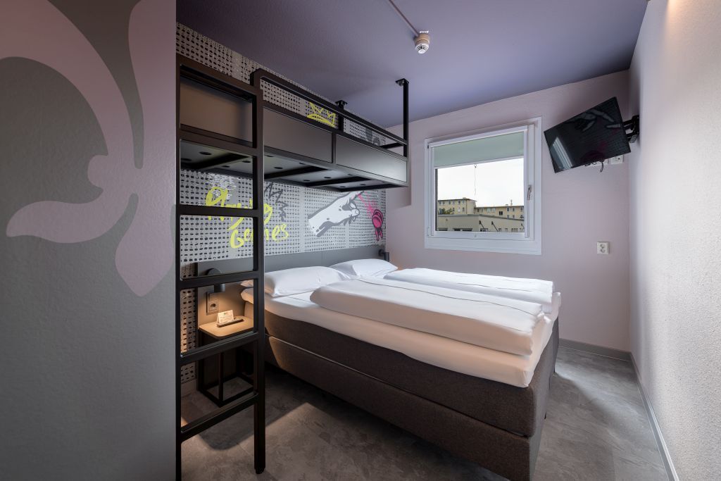 Kleines Schlafzimmer in der Stadtmitte mit Etagenbett, Wandbildern, Fenster und grau-violetten Wänden
