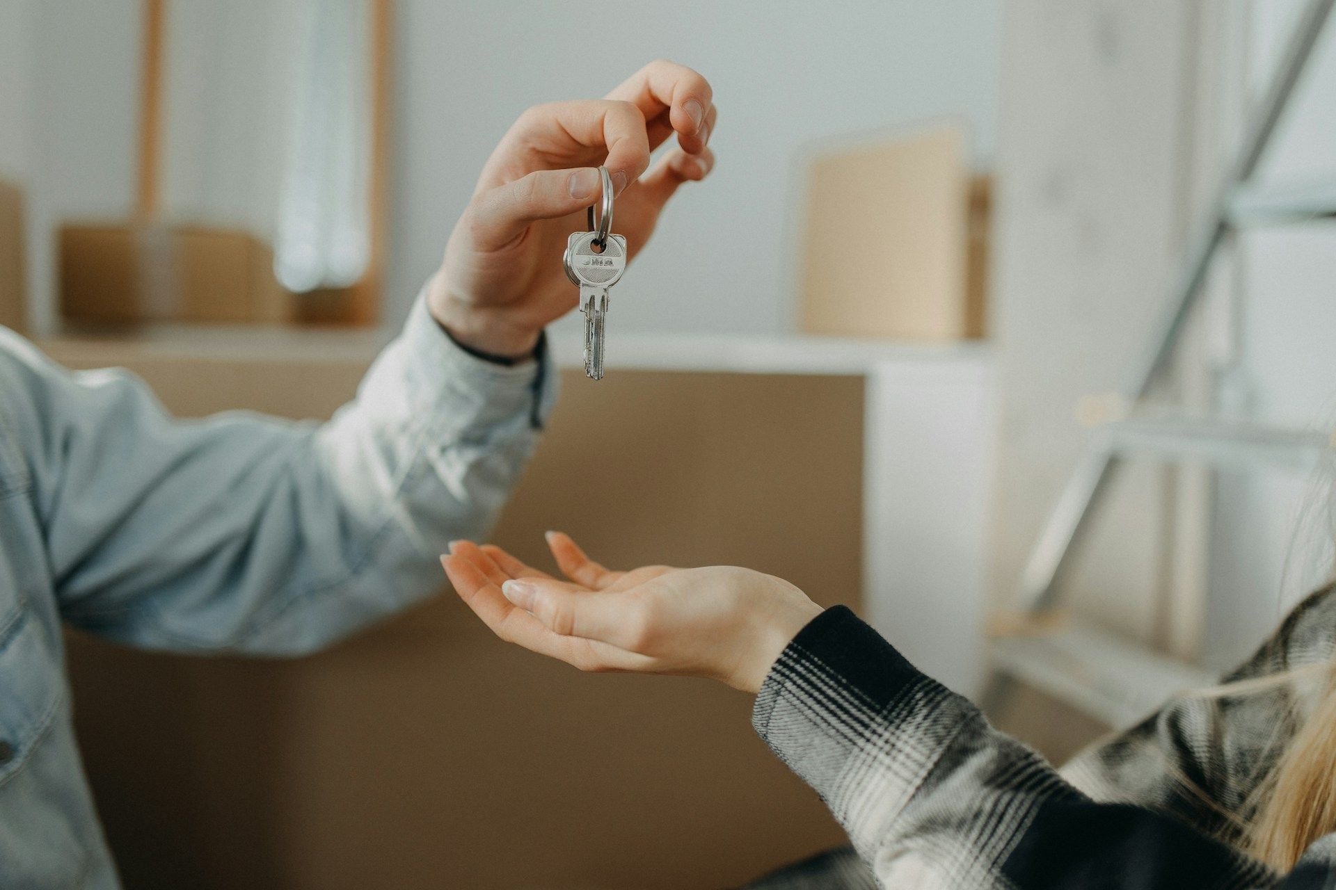 Handing over a set of keys to an outstretched hand in a home setting
