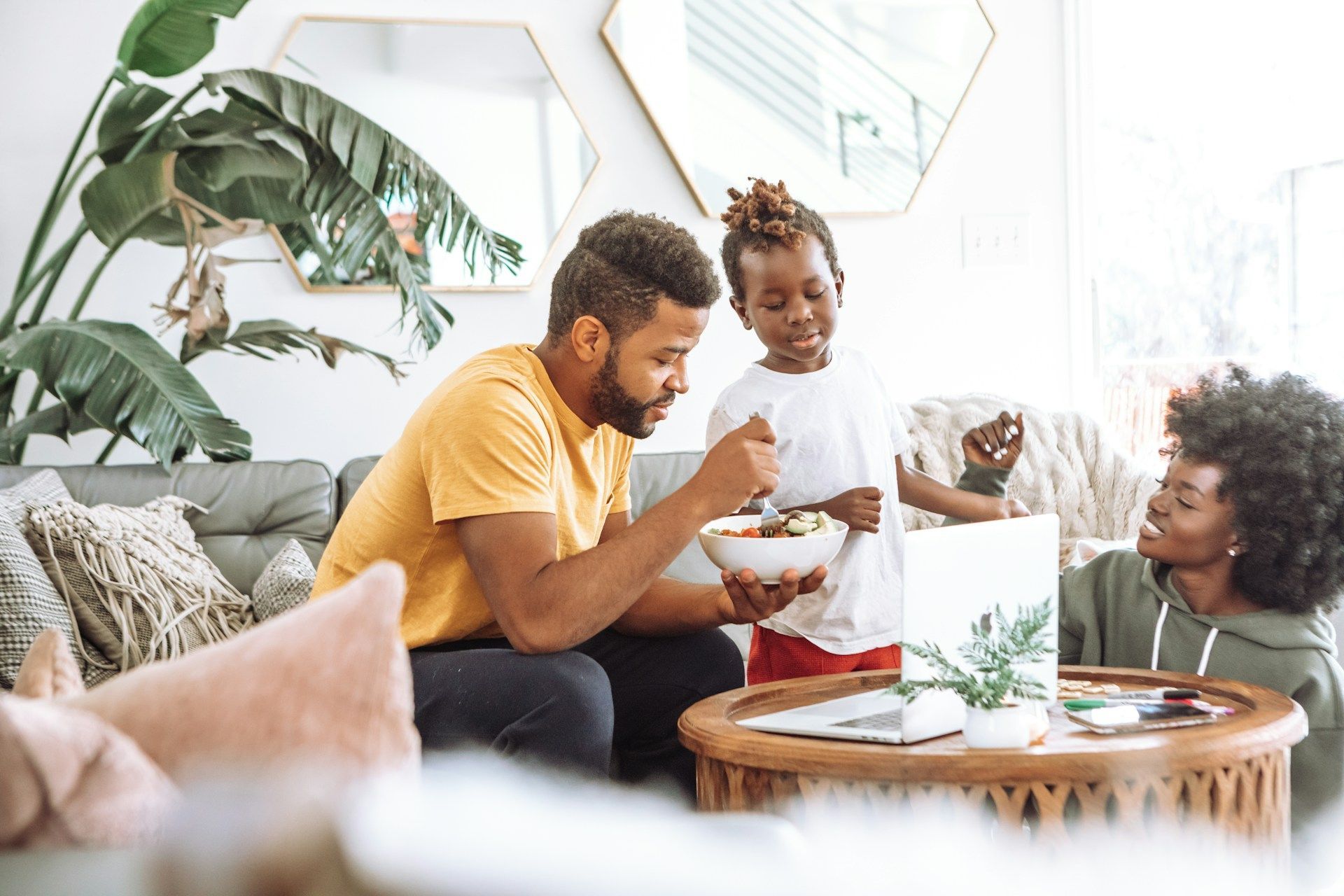 People eating and chatting around a coffee table in a bright living room