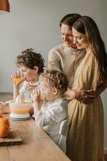 Family gathered around a table, blowing out candles on a birthday cake