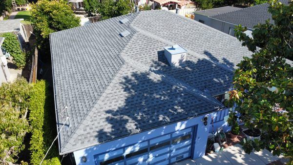 An aerial view of a house with a roof and trees.