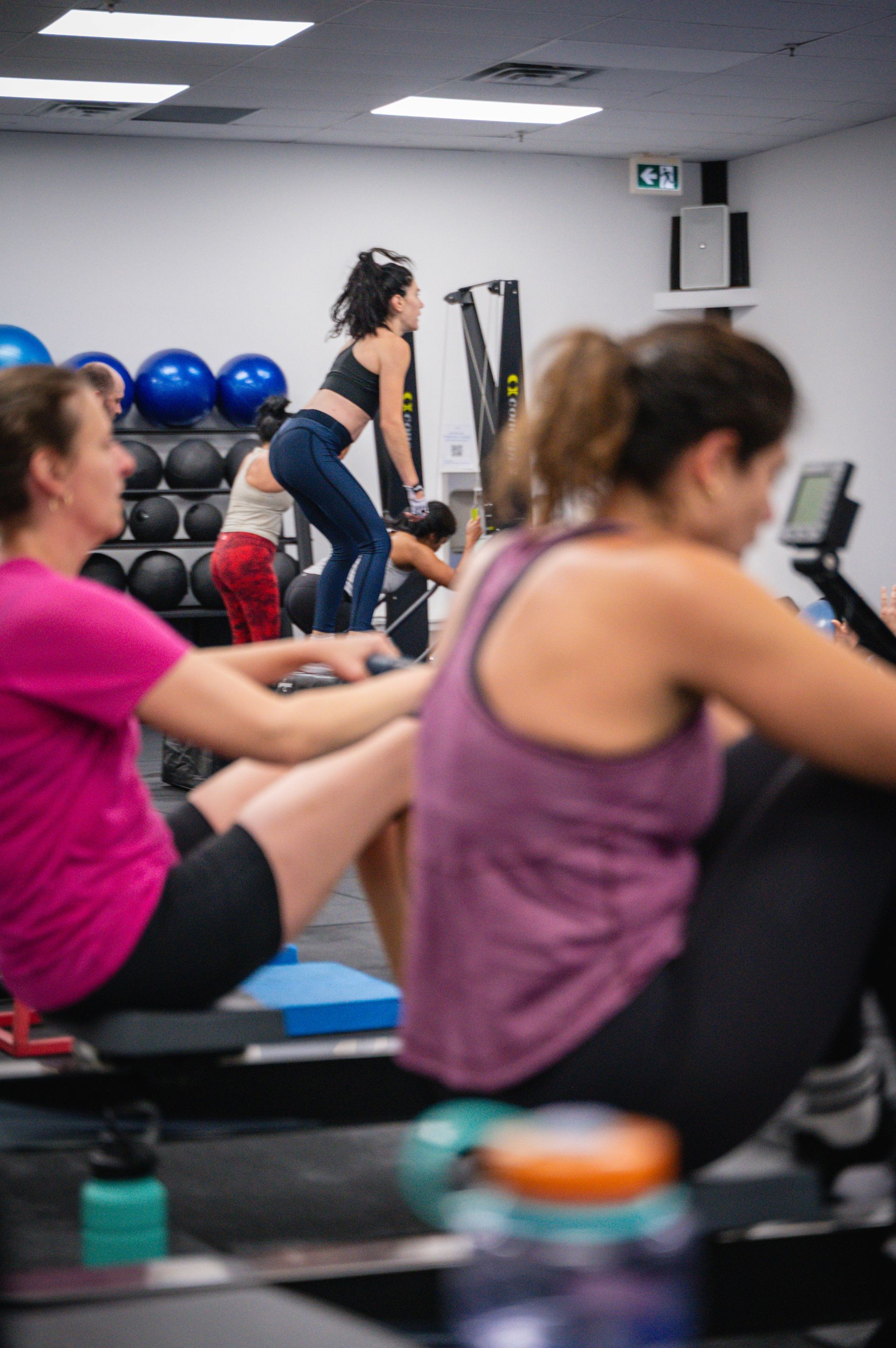 People exercising in Andwell Fitness, Toronto, ON gym, doing fast-paced workout moves on mats and floors