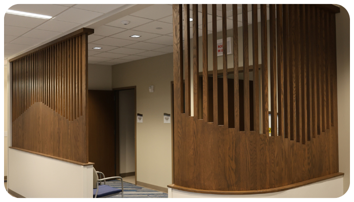 Wood-paneled hallway with vertical slats and a doorway in a beige office interior