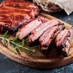 A close up of a piece of meat on a wooden cutting board.