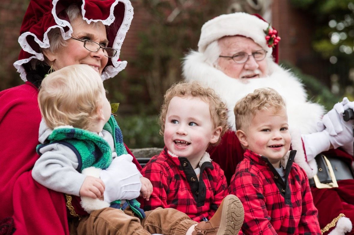 A group of children are sitting on a sleigh with santa claus. A group of children are sitting on a sleigh with santa claus.