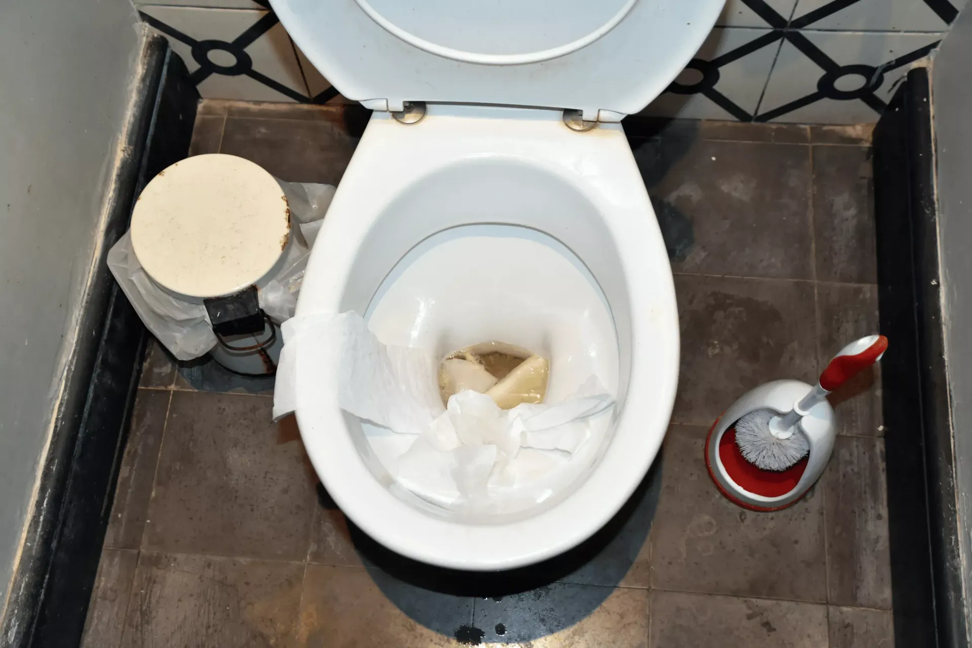 Overhead view of a clogged toilet with tissue blockage requiring emergency plumbing service in Bakersfield CA