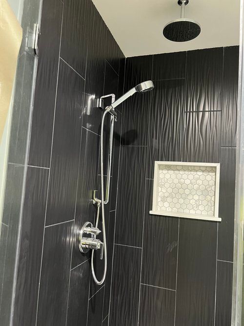 Modern bathroom with rain shower head and handheld shower fixture installed by Top Grade Plumbing in Bakersfield CA