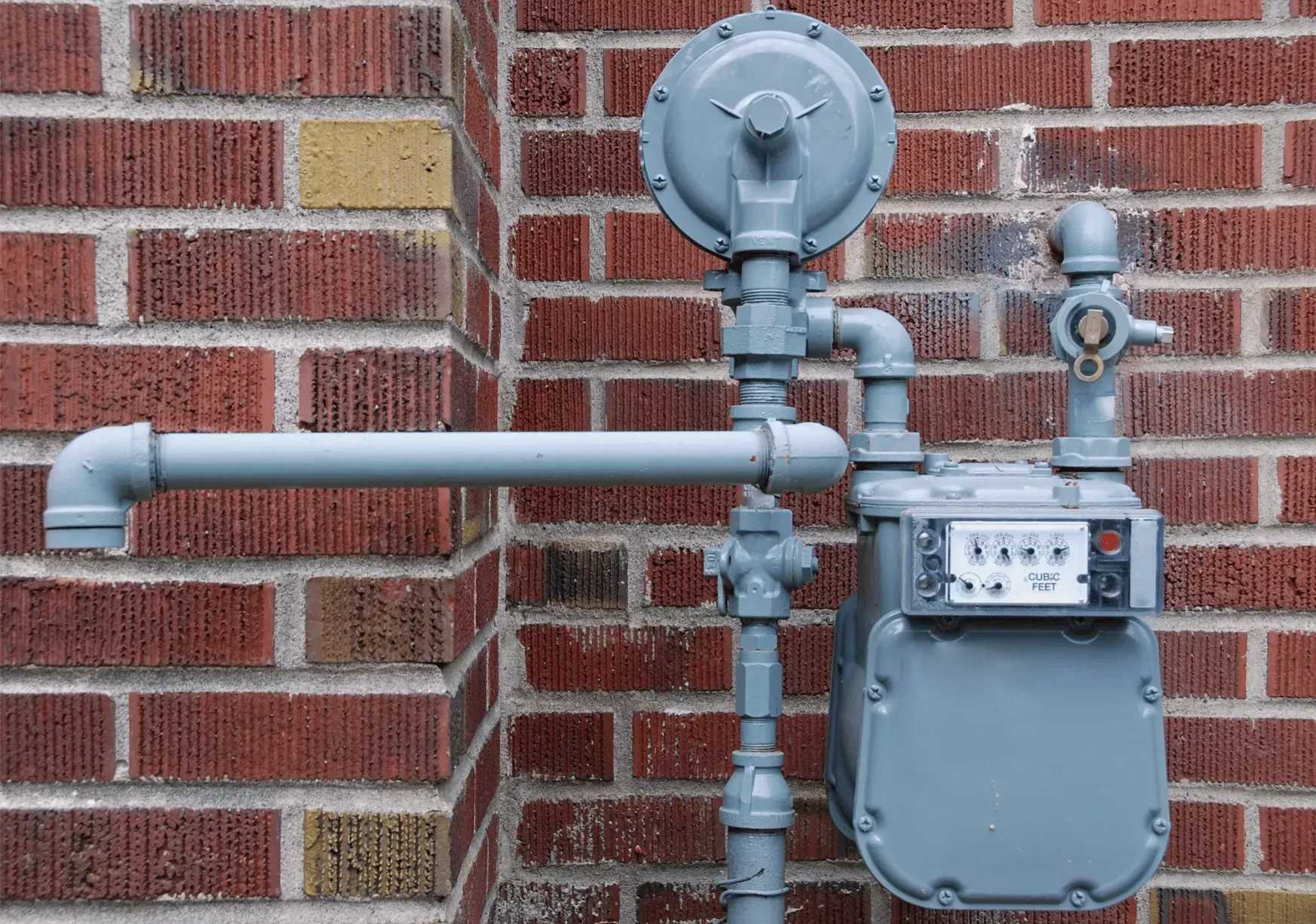 Residential gas meter and gas line on a brick exterior wall serviced during an emergency plumbing call in Bakersfield CA