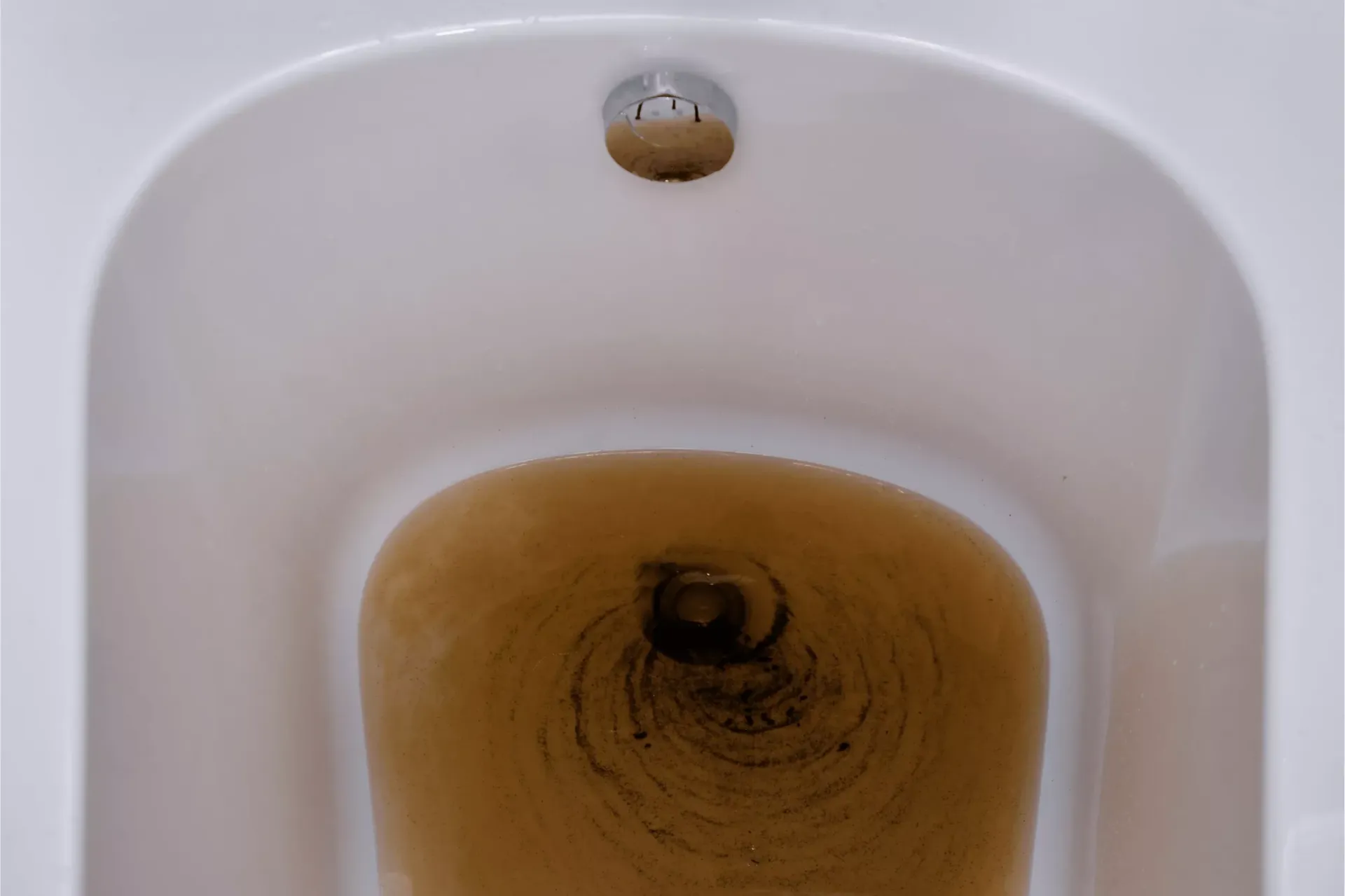 Sewage backing up into a bathtub with dirty water during a plumbing emergency in Bakersfield CA