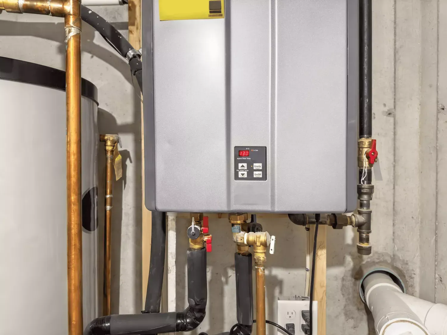Tankless water heater professionally installed with copper pipe connections by Top Grade Plumbing in Bakersfield CA