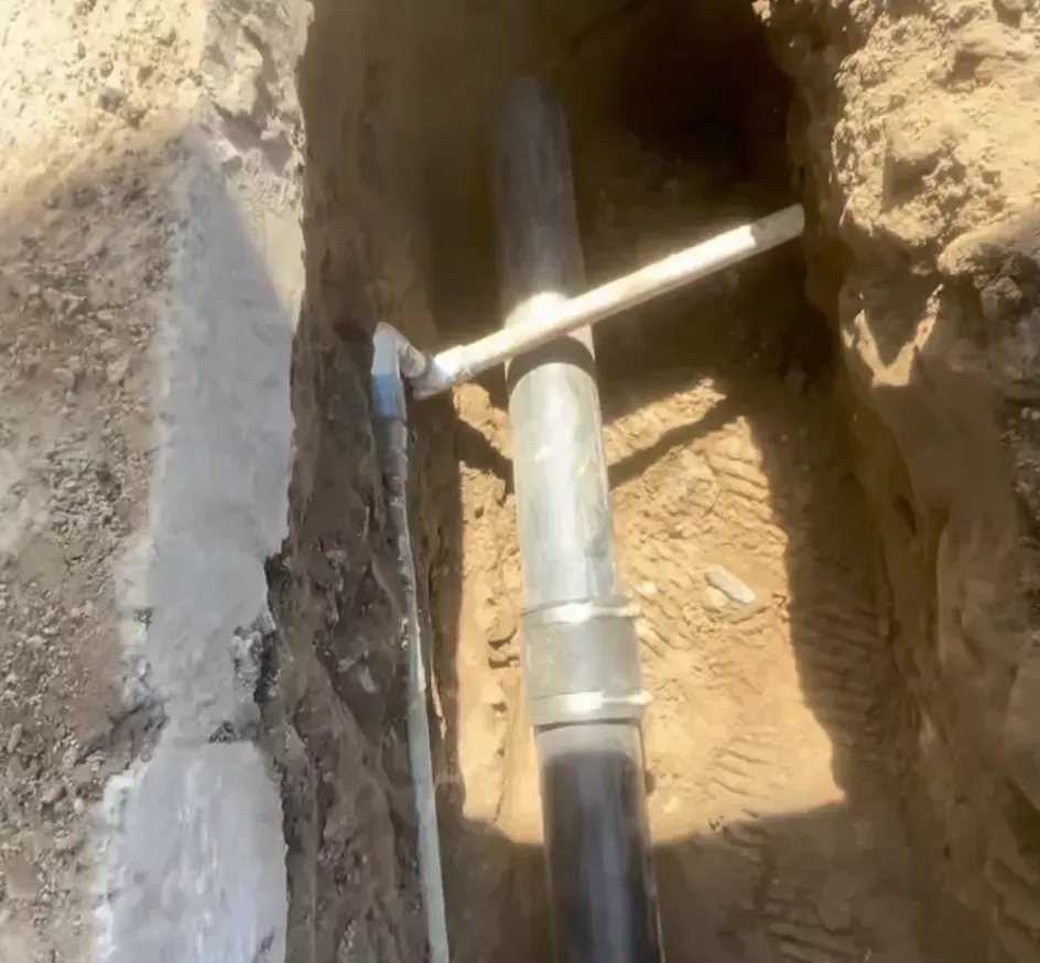 Excavated trench showing underground pipe repair completed by Top Grade Plumbing in Bakersfield CA