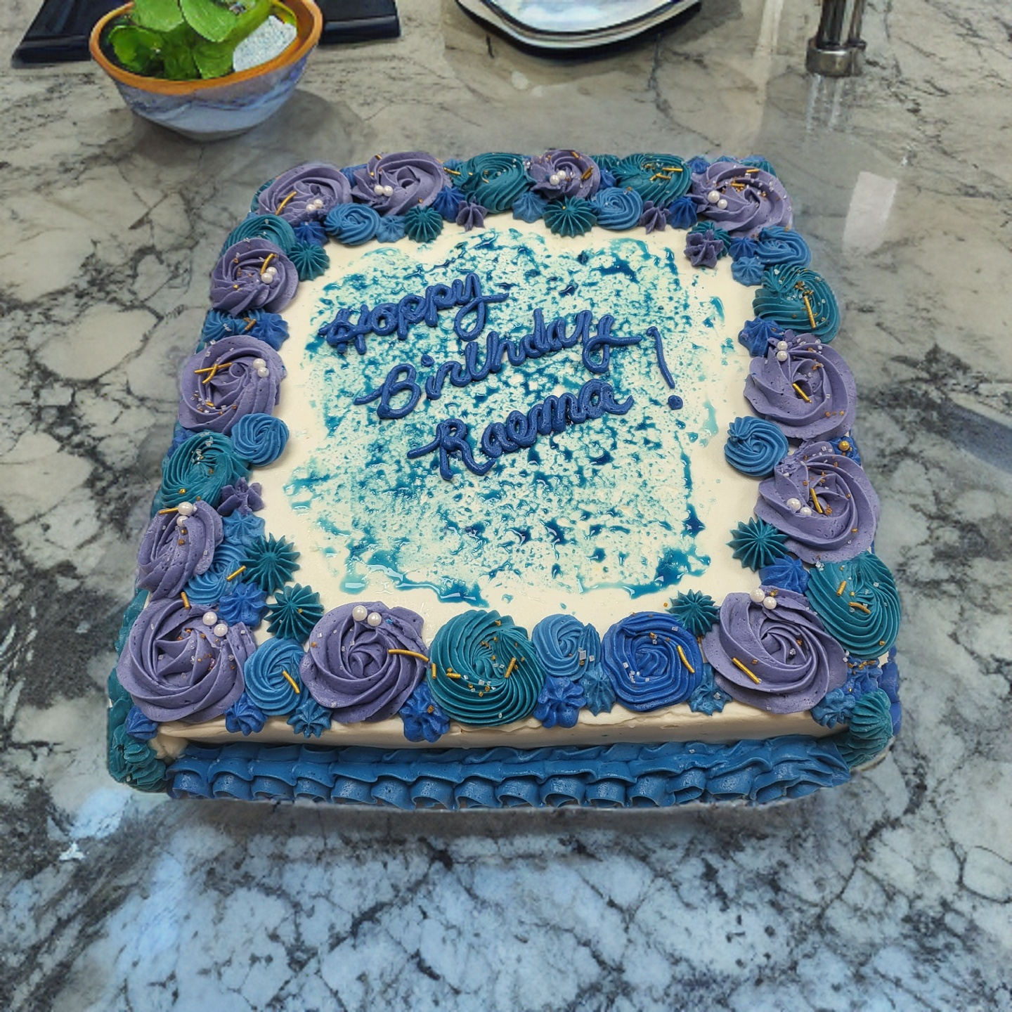 A birthday cake with blue frosting and the name regina on it