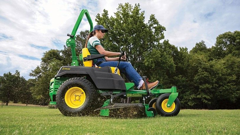 A Woman Is Riding a John Deere Zero Turn Lawn Mower on A Lush Green Field | Onalaska, WI | River City Irrigation