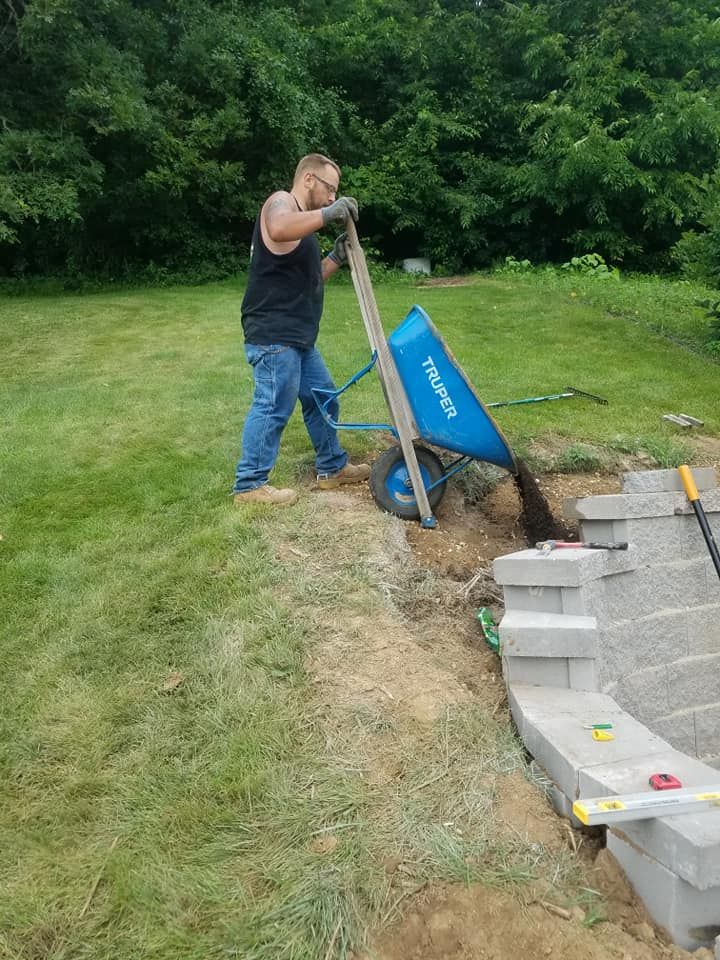 A Man Is Pushing a Wheelbarrow in A Yard | Onalaska, WI | River City Irrigation