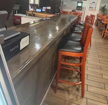 Bar counter with tall orange stools in a restaurant or café interior