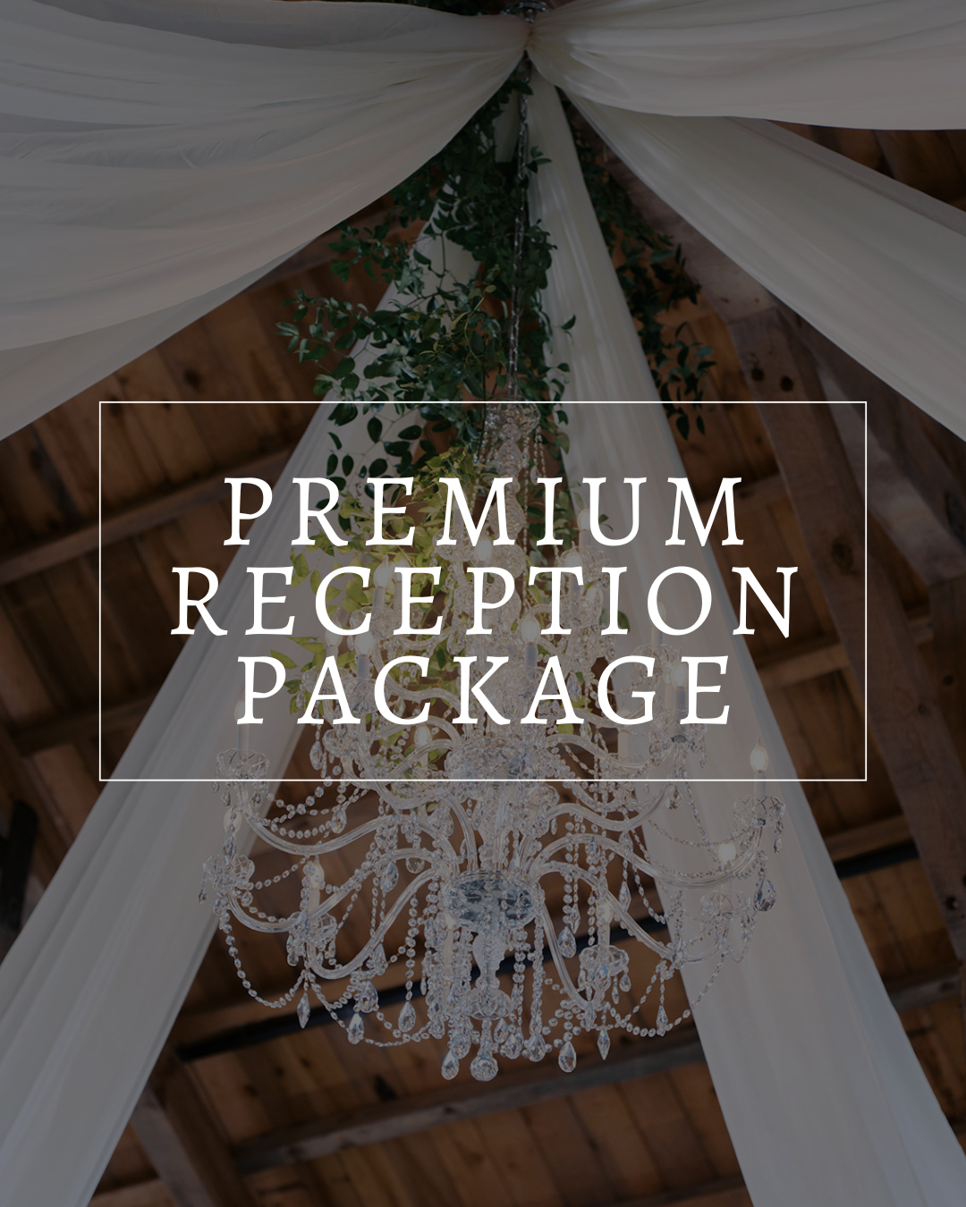 A crystal chandelier hangs from a rustic wooden ceiling, draped with white fabric and greenery, with