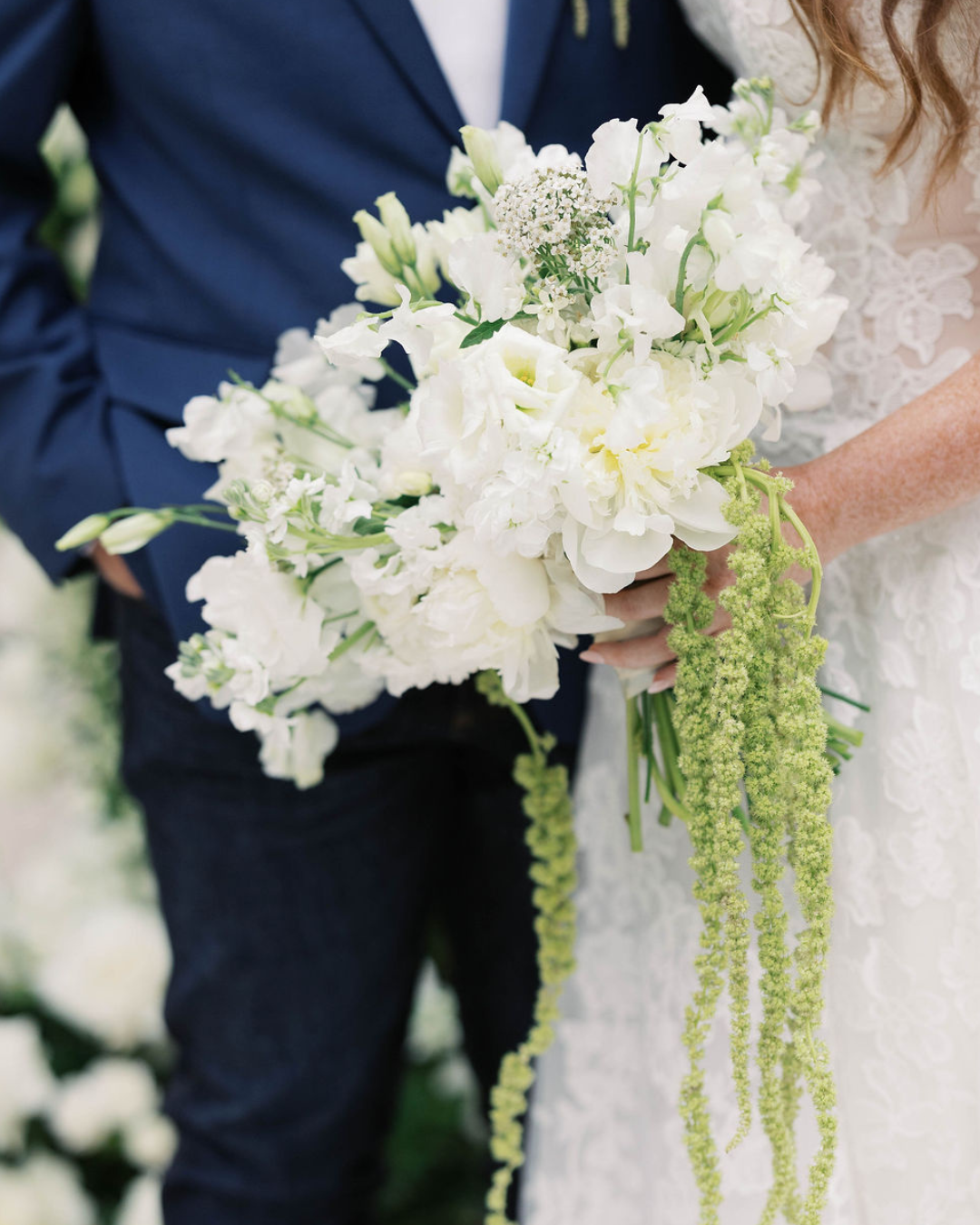 Bride and groom holding a white and green wedding bouquet