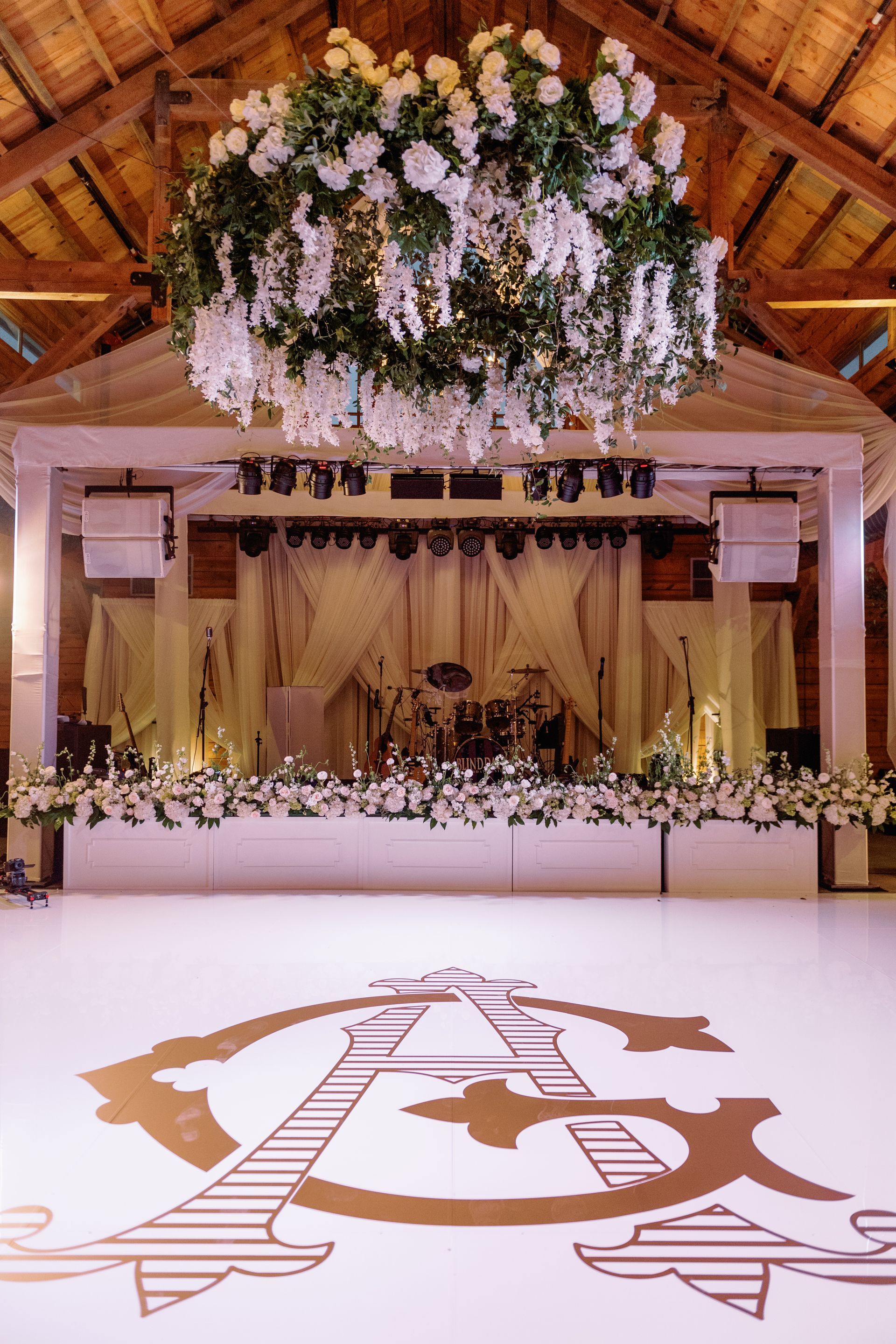 A white dance floor with a large, golden, monogrammed 