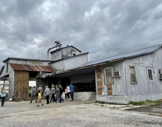 A group of people are standing in front of a large building.