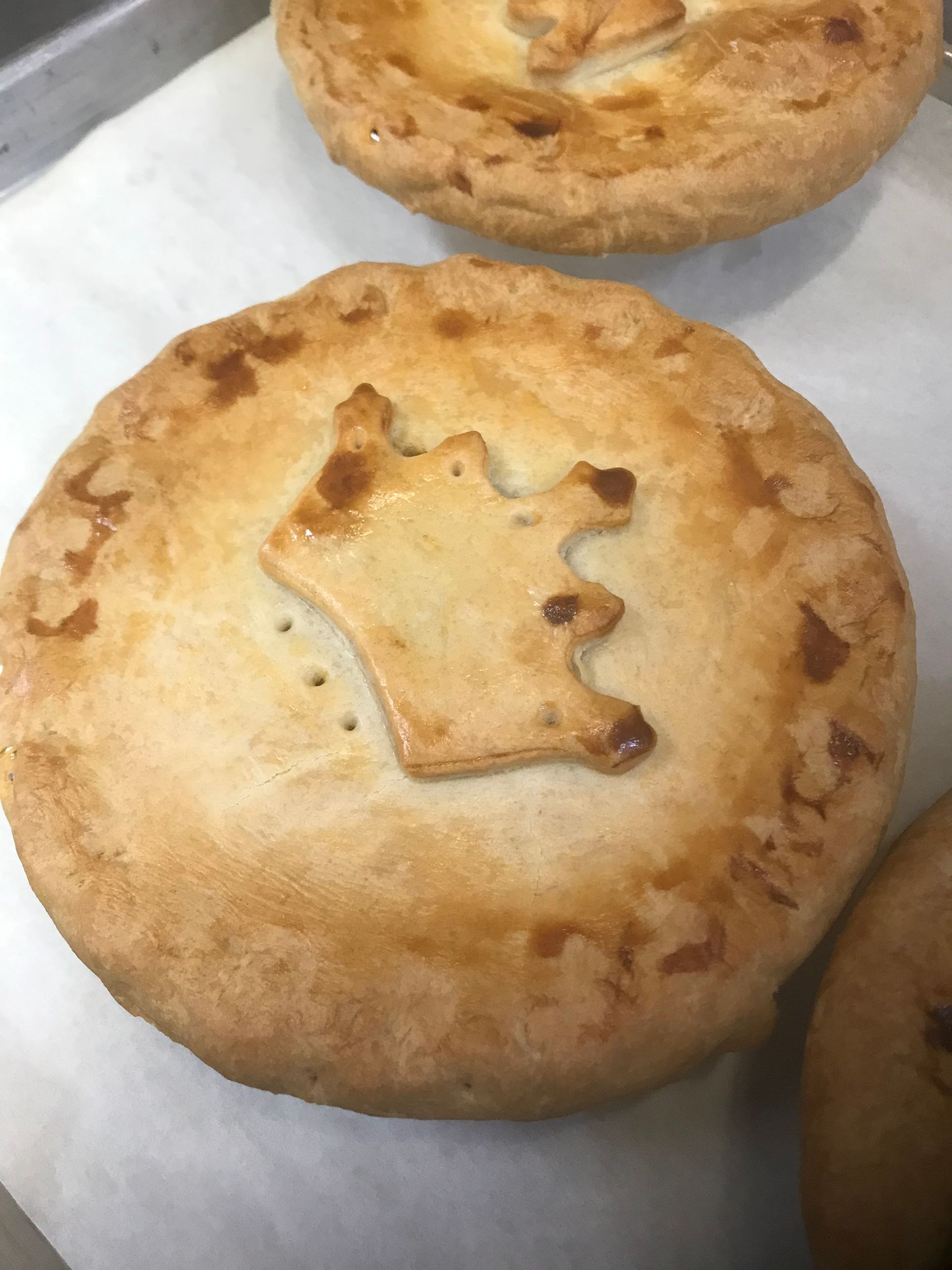 A pie with a crown on it is sitting on a table.