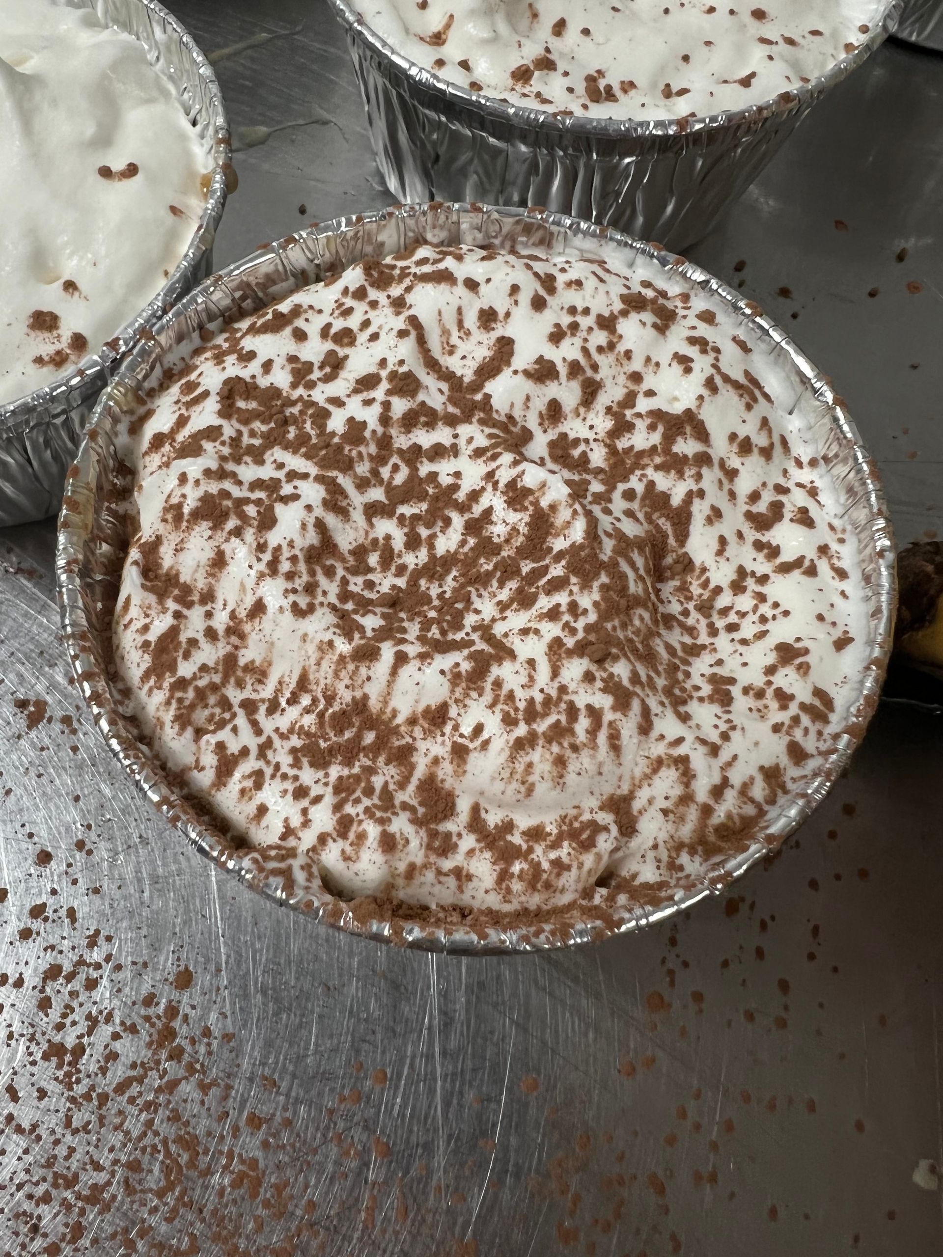 A close up of a dessert with whipped cream and chocolate sprinkles
