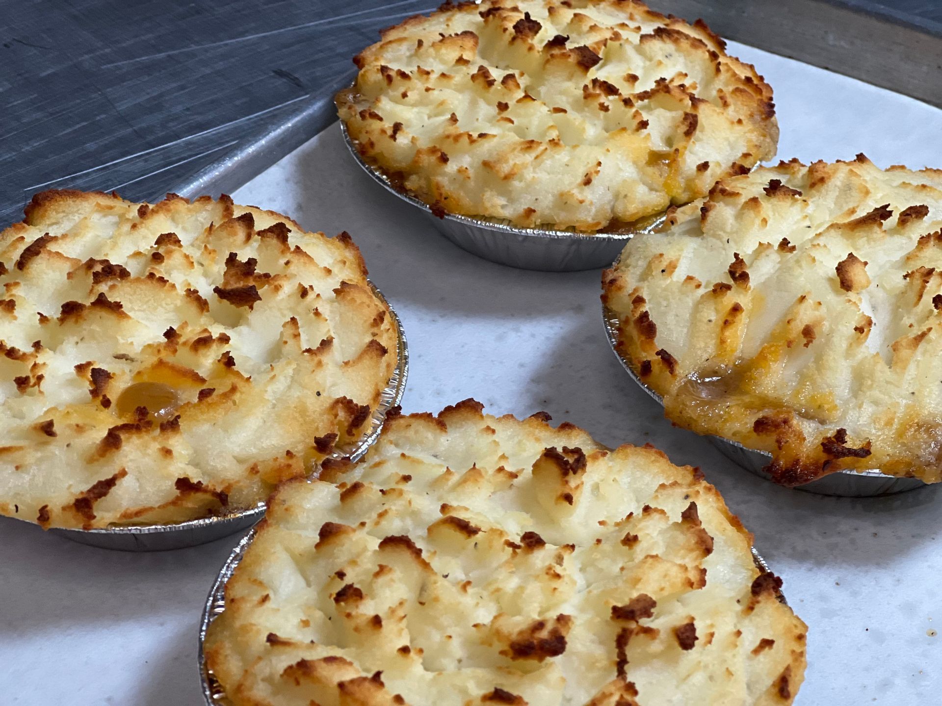 Four potato pies are sitting on a table.