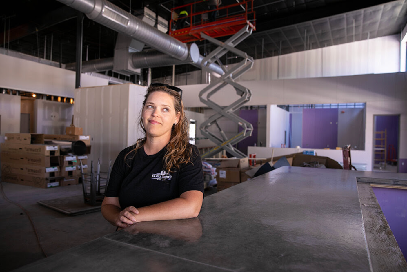 Leah Callahan is leaning on a counter at 14 Mill Market under construction.