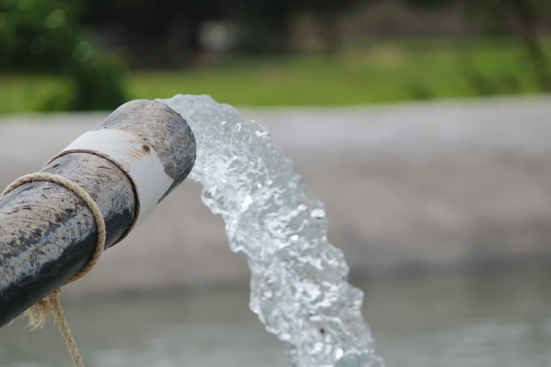 A steady stream of water flowing from a pipe after a professional pump service on-site. A steady stream of water flowing from a pipe after a professional pump service on-site.