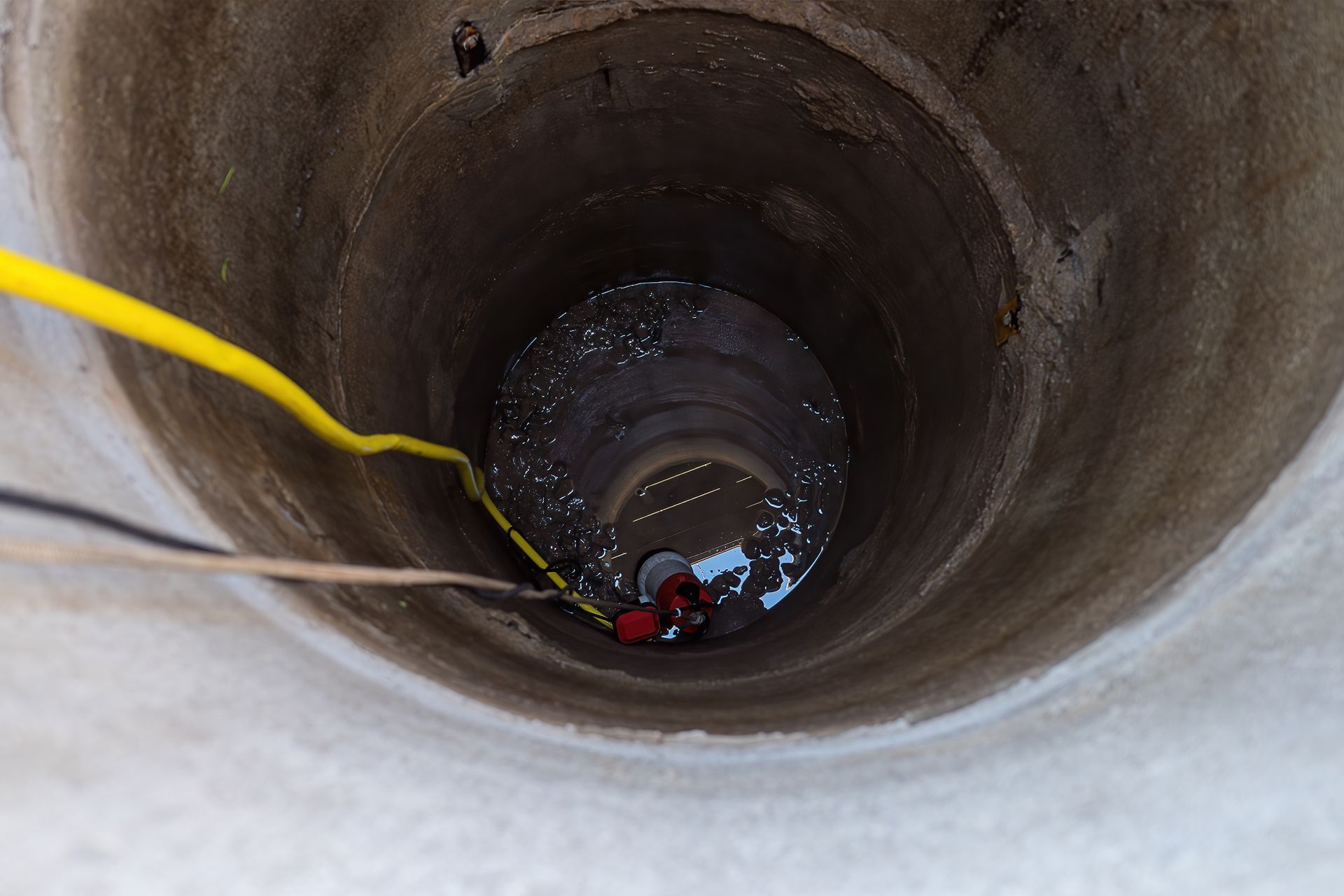 A pump lowered into a deep well for pumping out water.