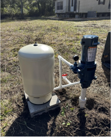 Above-ground well pump and pressure tank installed outside an Orange Park, FL home.