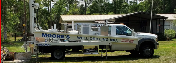 Moore's Well Drilling truck-mounted drilling rig parked on a residential property for a new well installation. Moore's Well Drilling truck-mounted drilling rig parked on a residential property for a new well installation.