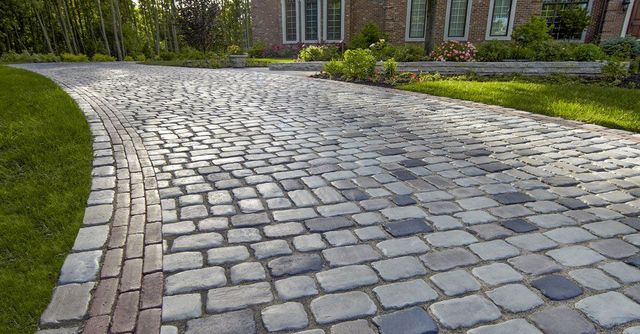 Grey cobbled driveway curving past a lawn with a red brick edge in Sheffield