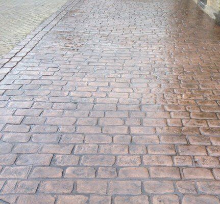Cobble-effect pattern imprinted concrete in warm red tones
