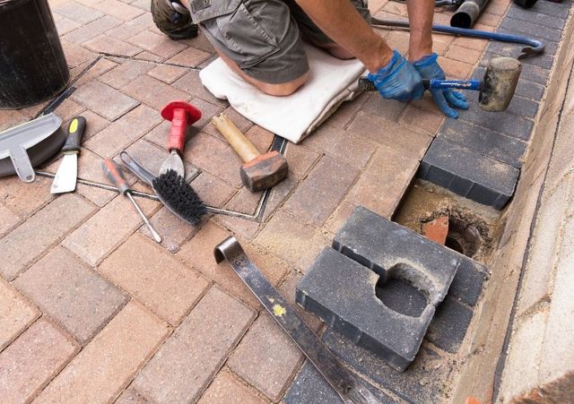 Block paving being installed with hand tools and a rubber mallet in Handsworth, Sheffield