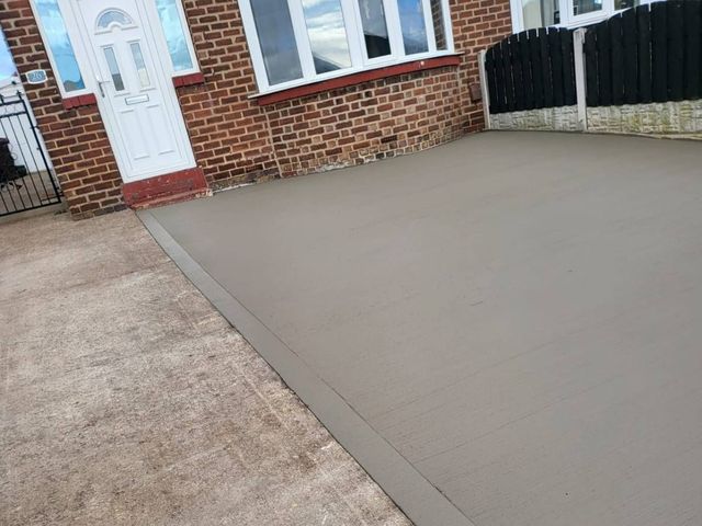Brushed concrete driveway leading to a white front door