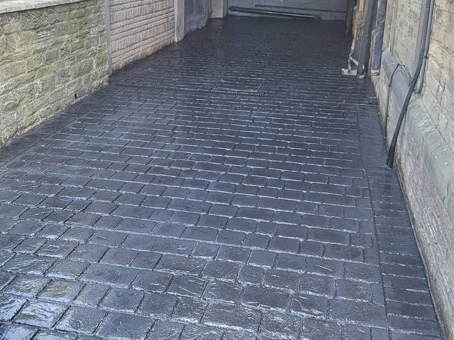 Dark slate imprinted concrete driveway with a sealed finish in Sheffield