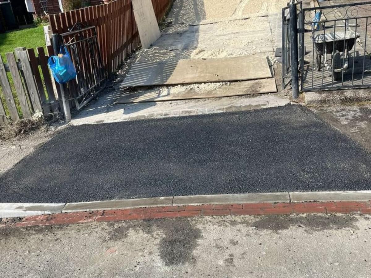 New dropped kerb with a tarmac crossover to a driveway gate in Sheffield