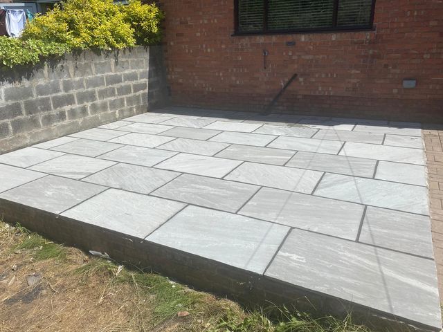 Light grey Indian stone patio against a brick house in Handsworth, Sheffield