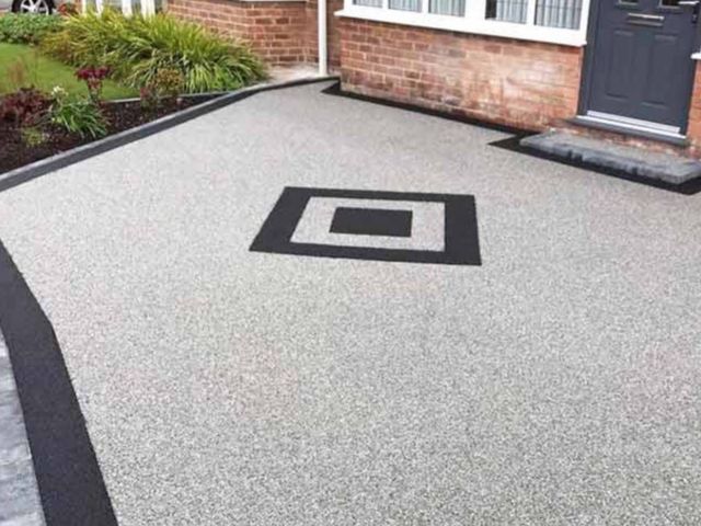 Light grey resin driveway with a black border and square feature pattern in Sheffield