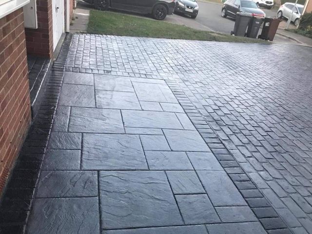 Grey pattern imprinted concrete driveway with a block border in Sheffield