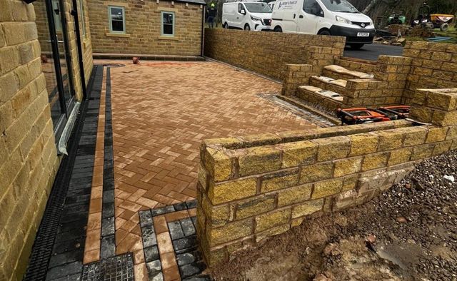 Buff herringbone block paving with two-tone edging, stone walling and steps in Crosspool, Sheffield