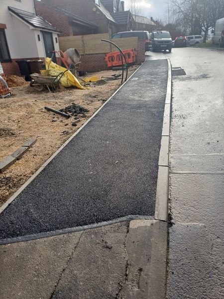 Finished tarmac footway with dropped kerbs outside new houses in Sheffield