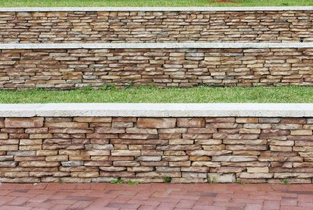 Two tiers of stone-faced retaining walls with a lawn between in Sheffield