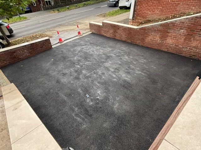 New black tarmac driveway between brick walls on Bocking Lane, Sheffield