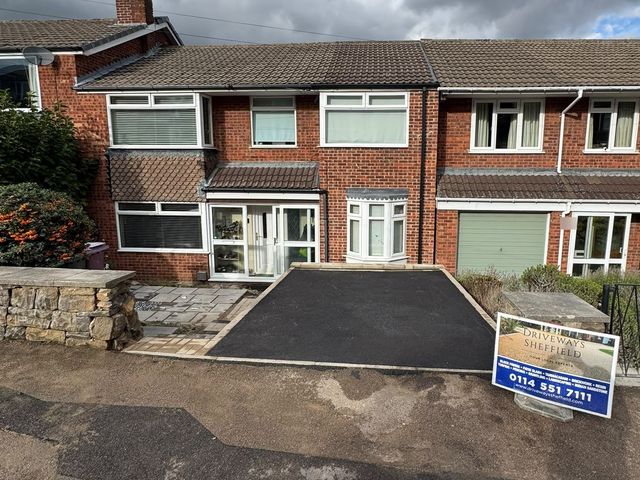 New black tarmac driveway with a block paving edge in front of a red brick house in Dronfield