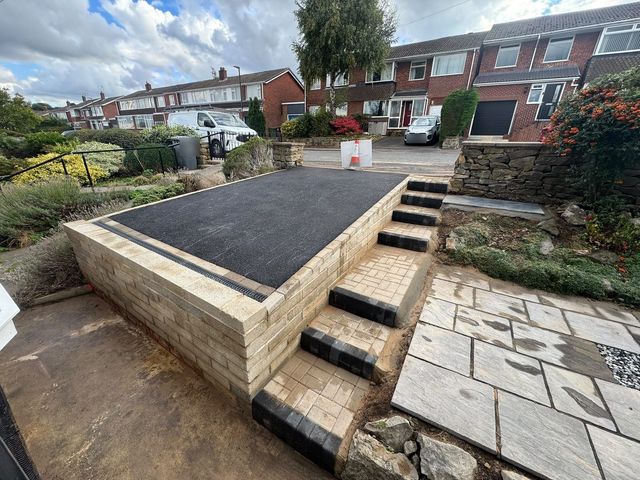 Raised tarmac driveway on a new buff block retaining wall with block paved steps in Dronfield