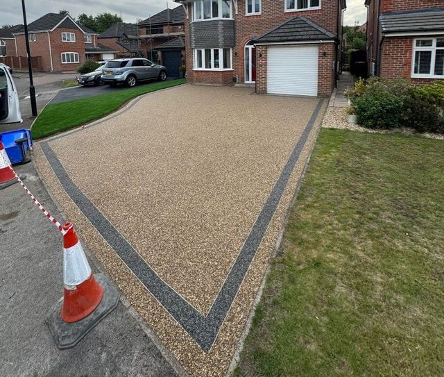 Resin bound driveway with a contrasting border leading to a garage in Oughtibridge