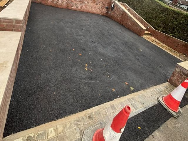 New black tarmac driveway with a cobble sett border at the pavement edge on Bocking Lane, Sheffield