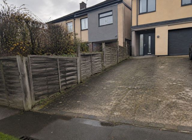 Old concrete driveway and worn timber fence beside a house in Sheffield before work started