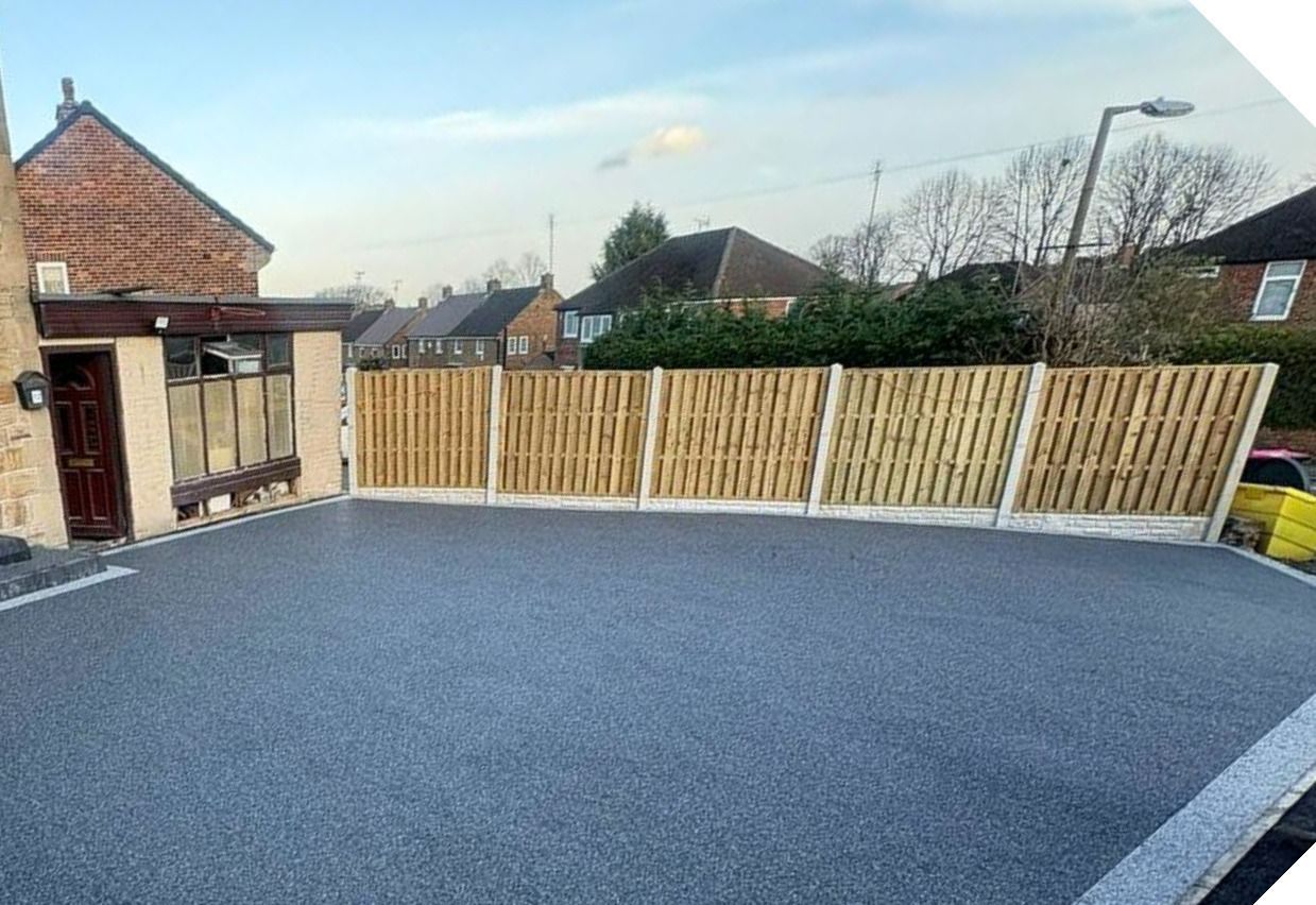 Wooden fence panel installation between concrete posts by resin driveway in Sheffield 